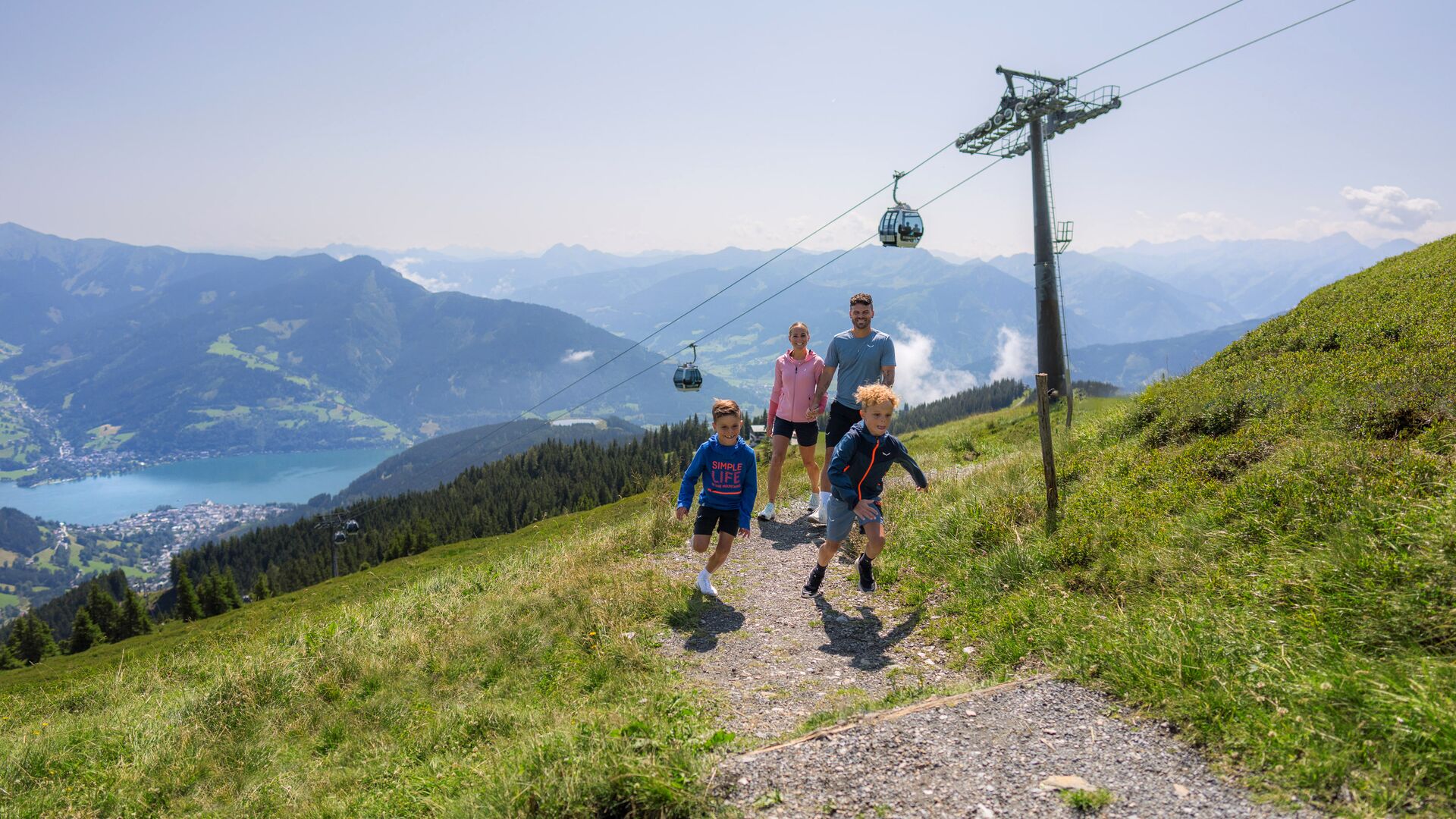 Familie auf einem Wanderweg unter dem trassXpress, die Kinder laufen vor den Eltern