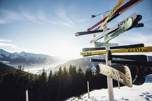 Gipfel des Ronachkopf mit Blick in eine winterliche Berglandschaft. Im Vordergrund ist ein Wegweiser zu sehen. | © Zell am See-Kaprun Tourismus