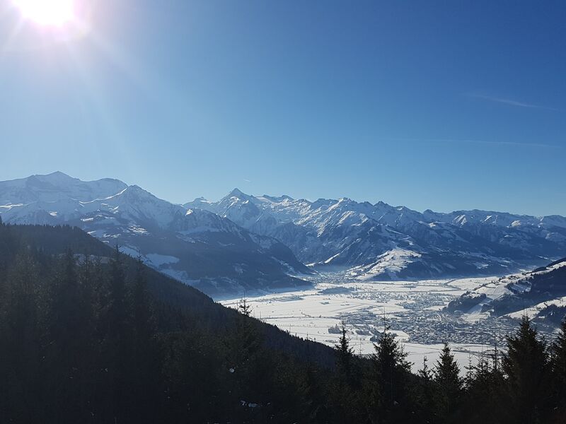 Aussicht vom Ronachkopf: Schneebedeckte Berge unter blauem Himmel | © Schmittenhöhebahn AG Aussicht vom Ronachkopf: Panoramablick auf schneebedeckte Berge und Tal im Winter. | © Schmittenhöhebahn AG