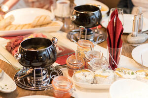 Ein gedeckter Tisch mit Suppe, frischem Brot und Dips in der AreitAlm. | © Schmittenhöhebahn AG/Nikolaus Faistauer Photography