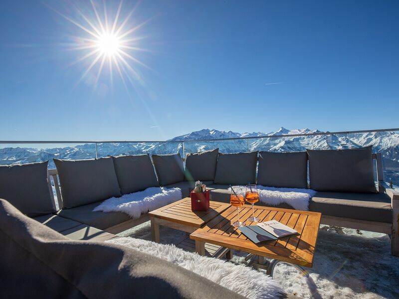 Gemütliche Lounge mit Blick auf schneebedeckte Berge. | © Schmittenhöhebahn AG/Nikolaus Faistauer Photography