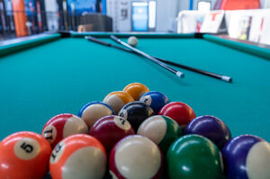 Close-up of a pool table with balls and a cue. | © Schmittenhöhebahn AG