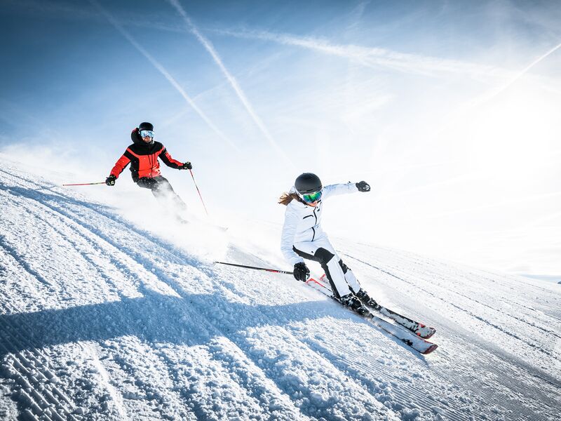 Skiabenteuer in der winterlichen Berglandschaft | © Intersport Bründl Zwei Skifahrer fahren auf einer schneebedeckten Piste. | © Intersport Bründl