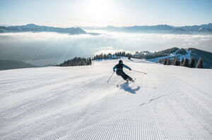Skifahrer auf präparierter Piste mit Bergpanorama | © Johannes Radlwimmer