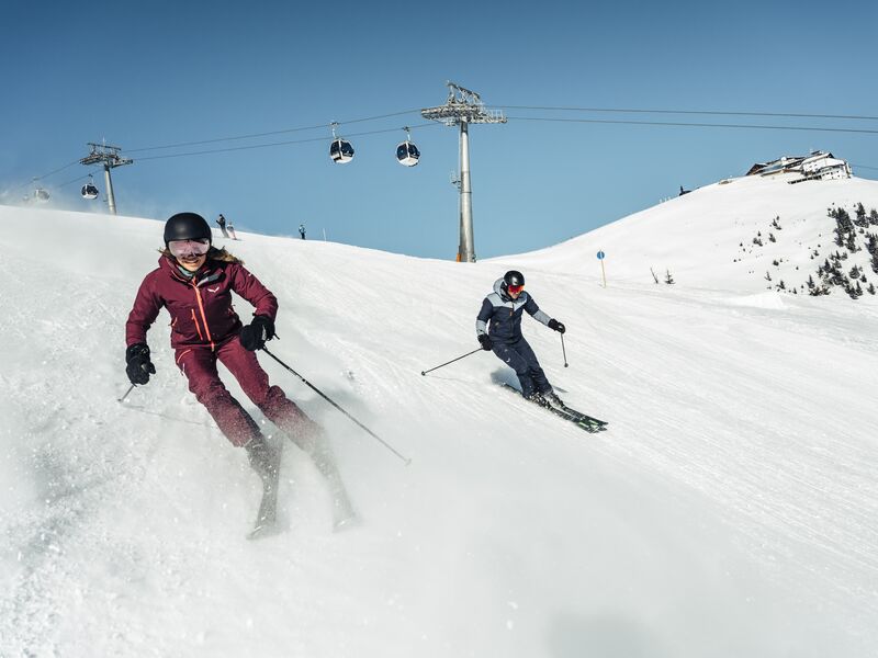 Skiabenteuer im verschneiten Gebirgsklima | © Korbinian Seifert Zwei Skifahrer genießen die Abfahrt auf einem schneebedeckten Hang. | © Korbinian Seifert