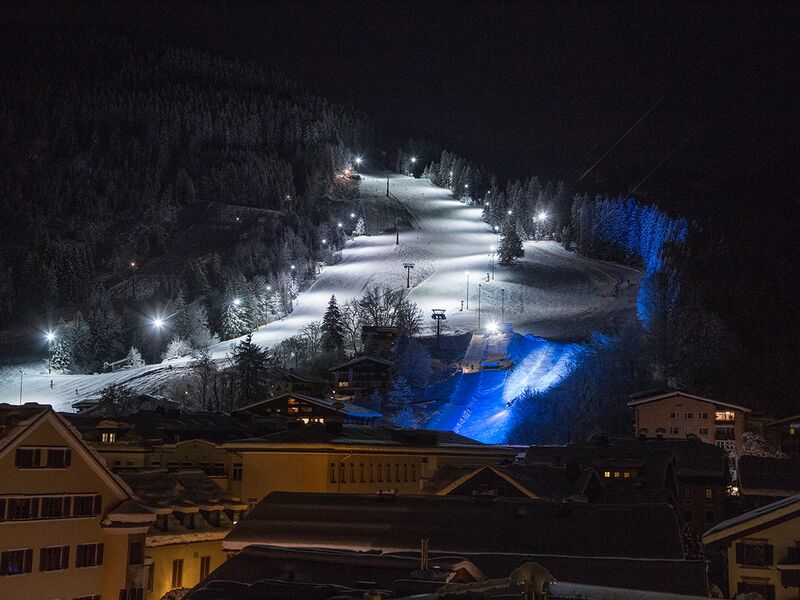 Nachtansicht eines beleuchteten Skigebiets | © Schmittenhöhebahn AG/Nikolaus Faistauer Photography Beleuchtete Skipiste mit Sessellift in der Nacht. | © Schmittenhöhebahn AG/Nikolaus Faistauer Photography