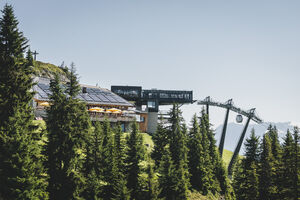 Mountain station with solar panels and cable car, surrounded by trees | © Stefanie Oberhauser