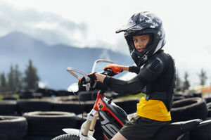 Child on electric motocross bike with protective gear and helmet in the E-Motocross Park. | © Schmittenhöhebahn AG