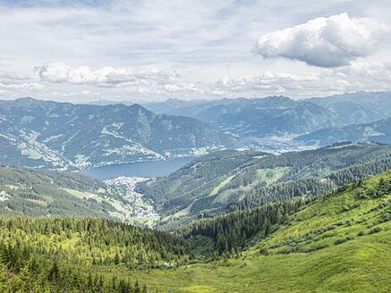 Blick über grüne Hügel und einen See in den Bergen. | © Schmittenhöhebahn AG/Max Steinbauer