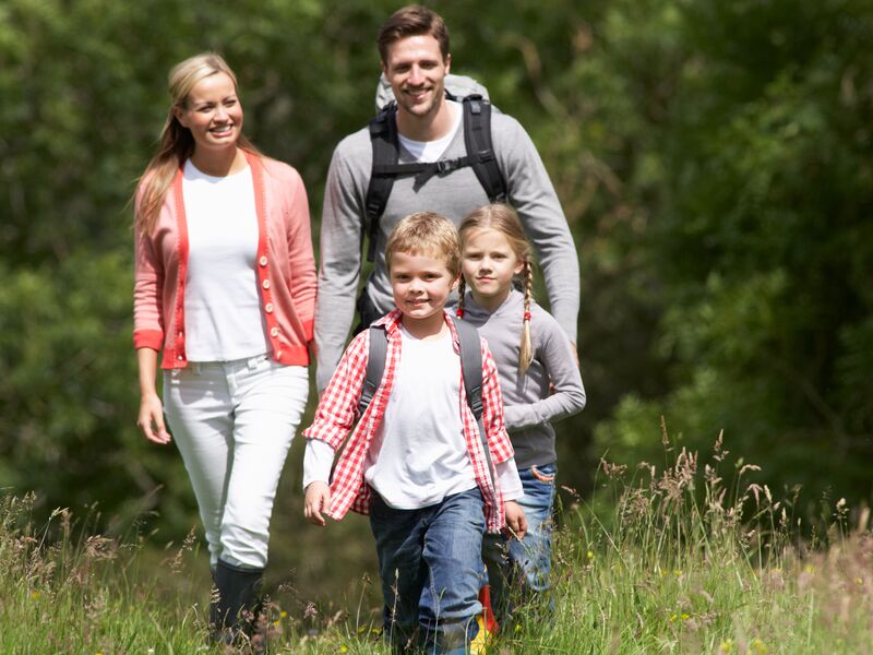 Eine Familie mit zwei Kindern genießt einen Spaziergang im Freien. | © Schmittenhöhebahn AG/Ingimage