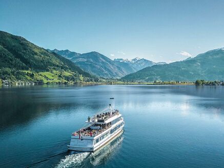 Das Schiff MS Schmittenhöhe fährt auf einem ruhigen See, umgeben von Bergen. | © Schmittenhöhebahn AG