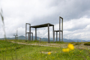 An artistic structure on the meadow, surrounded by mountains. | © Schmittenhöhebahn AG/mr-offenblende.at