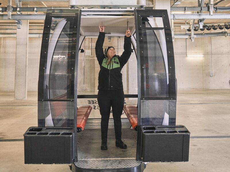 Betriebsleiterin Celina Schuster überprüft die Mechanik einer Seilbahngondel in einer Halle. | © Robert Maybach